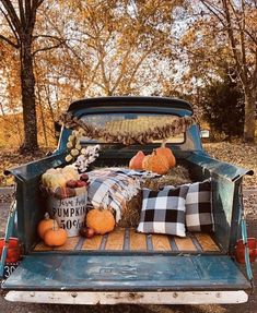 an old pick up truck with pumpkins and hay in the back