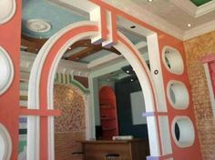 an arch in the middle of a room that has been painted with different colors and shapes