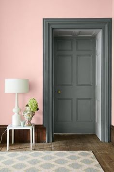 a room with pink walls and grey doors