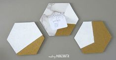 three white and gold hexagonal mirrors with labels on them