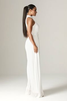 Feminine, floaty and perfect for Spring. Cut from breezy georgette chiffon for a fresh feel in elegant ivory, 'Fadia’ has a wide belt to cinch the waist . The classic halter shape silhouette and accentuates the figure whilst prioritizing luxurious comfort. and we love how the pleated waist falls to a flared long hem for feminine flair.It's fully lined for comfort and zips up the back for easy on. Wear yours with delicate accessories like our 'Adrien' necklace.WHERE TO WEAR:Pretty date nights, bo Summer Formal Chiffon Jumpsuits And Rompers, Elegant Maxi Length Workwear Jumpsuits And Rompers, Elegant Workwear Maxi Jumpsuits And Rompers, Chic Fitted Chiffon Jumpsuit, Chic Fitted Chiffon Jumpsuits And Rompers, Elegant Flowy Jumpsuits For Summer, Elegant Chiffon Jumpsuits And Rompers For Spring, Elegant Flowy Summer Jumpsuits And Rompers, Elegant Flowy Jumpsuits And Rompers For Summer