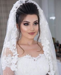 a woman in a wedding dress with a veil on her head