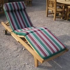 an empty lounge chair sitting in the middle of a gravel area with tables and chairs around it