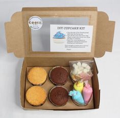 an open cardboard box with cupcakes in it