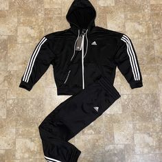 Game Day Begins The Moment You Wake Up. Slip On This Adidas Track Suit To Stay Cozy As You Head To The Gym Or Grab A Pre-Game Meal. The Hoodie Has A Loose Cut For Easy Layering. Both Pieces Keep You Dry, Comfortable And Focused On What's Next. Loose Fit On Top, Regular Fit On Pants Full-Zip Jacket With Hood 100% Recycled Polyester French Terry Hooded Jacket And Pants Set Moisture-Absorbing Aeroready Kangaroo Pockets On Jacket Elastic Cuffs And Hem Drawcord-Adjustable Elastic Waist On Pants This Sporty Fitted Adidas Sets, Adidas Long Sleeve Athleisure Track Jacket, Black Long Sleeve Track Jacket With Adidas Logo, Casual Adidas Track Jacket With Double-lined Hood, Adidas Duffle Bag, Adidas Hooded Track Jacket With Moisture-wicking, Adidas Moisture-wicking Sportswear Track Jacket, Adidas Zip Up, Adidas Short