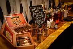 an assortment of cigars and liquor bottles on a table