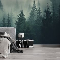 a bedroom with a forest mural on the wall and bed in the foreground, next to a night stand