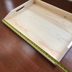 a wooden tray with measuring tape on the floor