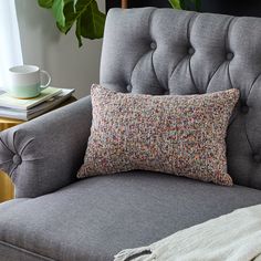 a gray chair with a pillow on top of it