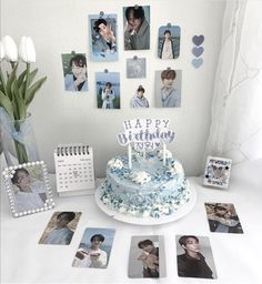 a birthday cake sitting on top of a table next to pictures and photos hanging on the wall