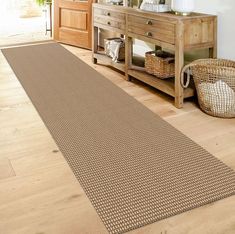 a large brown rug is in the middle of a room with a dresser and mirror