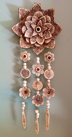 an intricately designed wall hanging with beads and flowers on the front, made out of wood