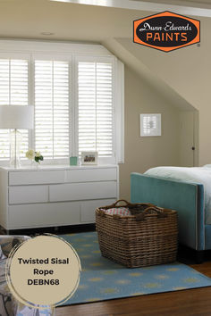 a bedroom with white shutters and a blue bed in the corner, next to a basket