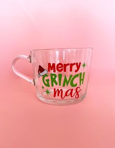 a glass mug with merry grinmas written on the side and santa's hat