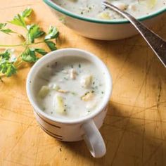 two bowls of soup on a table with a spoon and parsley next to it