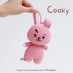 a pink crocheted bunny keychain hanging from a string with the words cooky written below it