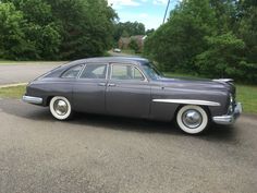 an old car is parked on the side of the road