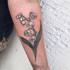 a woman's arm with a flower tattoo on it