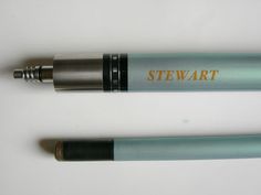 two pens sitting next to each other on top of a white table with the words stewart written on it