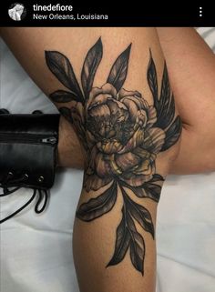 a woman's thigh with flowers and leaves on it