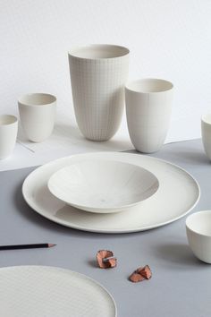 the table is set with white dishes and cups