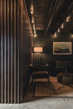 a living room filled with furniture and lights next to a wooden paneled wall on top of a hard wood floor