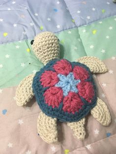 a crocheted turtle laying on top of a bed