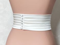 The Couture Pleated Bridal Belt is a stunning and elegant accessory that adds a touch of sophistication to any wedding dress. Handmade with meticulous attention to detail, this belt is crafted from luxurious matte satin, known for its smooth texture. The wide pleated design measures 3.5 inches (9cm) in width, creating a visually striking effect that cinches the waist and accentuates the curves. Width 3.5 inches (9cm) Fabric: Satin Duchess (shown in the photo) Color: light ivory (shown in the pho Luxury White Formal Belt, Elegant Corset Belt With Belt Loops, White Fitted Bridal Belt For Ceremony, Wedding Sashes With Satin Finish, Fitted White Bridal Belt, Elegant Satin Bridal Accessories For Wedding, Elegant Fitted Corset Belt With Belt Loops, Elegant Formal Sash With Satin Finish, Elegant Fitted Corset Belt With Sashes