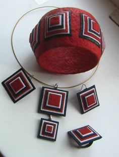 a red hat and some earrings on a table