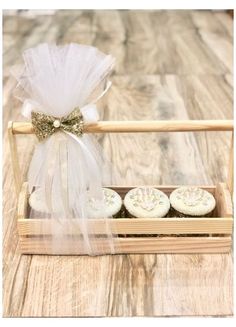 three cupcakes in a wooden box on a table