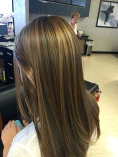 the back of a woman's head with long brown hair in an office setting