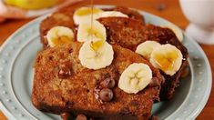 french toast with bananas and chocolate chips on a blue plate next to a cup of coffee