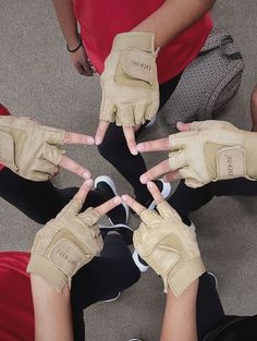 four people sitting in a circle with their hands on the top of each other's fingers