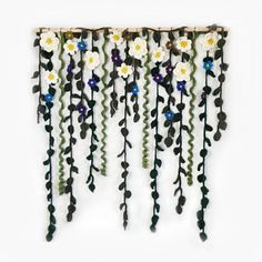 a wall hanging with flowers and leaves on it