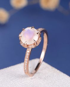 a white opal ring with diamonds on top and in the middle, sitting on a napkin