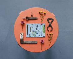 an orange table topped with scissors and flowers