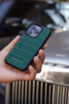 The person is holding a green luxury iPhone 14 Pro case in their hand. Luxury Rectangular Phone Accessories For Travel, Luxury Leather Phone Accessories For Everyday Use, Luxury Leather Phone Accessories, Modern Leather Phone Accessories, Rectangular Shape, Modern Leather Rectangular Phone Accessories, Modern Green Rectangular Cases, Leather Rectangular Phone Case, Leather Iphone Case, Luxury Phone Case