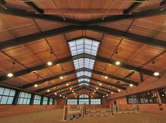 the inside of a horse barn with wooden ceiling and windows on each side of the room