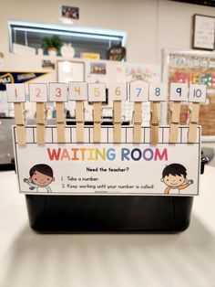 a classroom sign with clothes pins and pegs attached to it that says waiting room