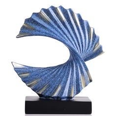 a blue and white shell sculpture on a black stand with a white backround