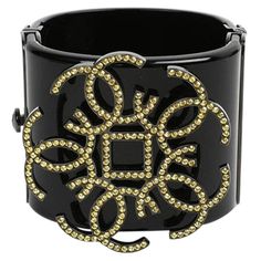 Amazing Black Chanel resin cuff. The small yellow rhinestones features the iconic CC logo. With a black clasp, the cuff is in good condition, just few marks. The Chanel stamp indicates it's been made in France in 2017. This item will be delivered with its Chanel's box. Chanel Cuff Bracelet, Chanel Cuff, Textures Fashion, Chanel Bracelet, Logo Yellow, Logo With A, Chanel Box, Chanel Logo, Black Resin