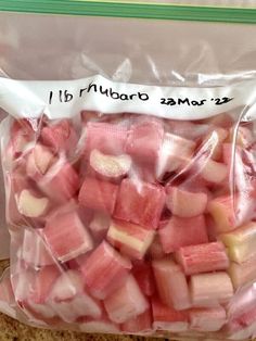 a bag filled with cubes of pink and white food sitting on top of a wooden table