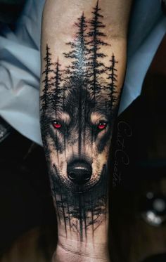 a man's arm with a wolf and trees on it