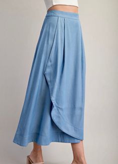 This flowing midi skirt has a high waist, front darts, front wrap detail, and side hidden in-seam zip closure. Midi Length Bottoms With Folds For Work, Midi-length Workwear Bottoms With Folds, Workwear Midi Bottoms With Folds, Blue Rayon Maxi Skirt For Spring, Rayon Midi Pleated Skirt, Rayon Pleated Midi Skirt, Spring Chic Flowy Culottes, Flowy Skirt Bottoms With Folds For Workwear, Spring Workwear Skirt With Side Slits