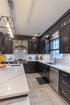 a kitchen with marble counter tops and stainless steel appliances, along with dark wood cabinets