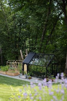 an outdoor play area in the middle of a yard with purple flowers and green grass