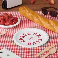 there is a plate with strawberries on it next to a bowl of strawberries