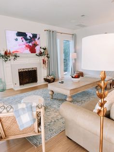 a living room filled with furniture and a large painting on the wall above the fireplace