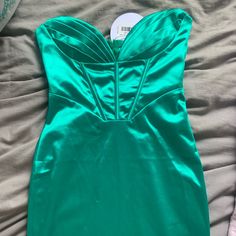 a green dress laying on top of a bed