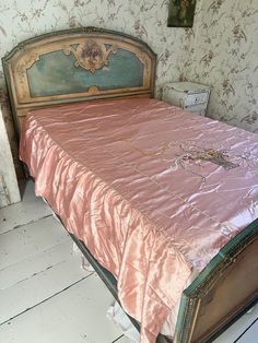 an old fashioned bed in a room with floral wallpaper